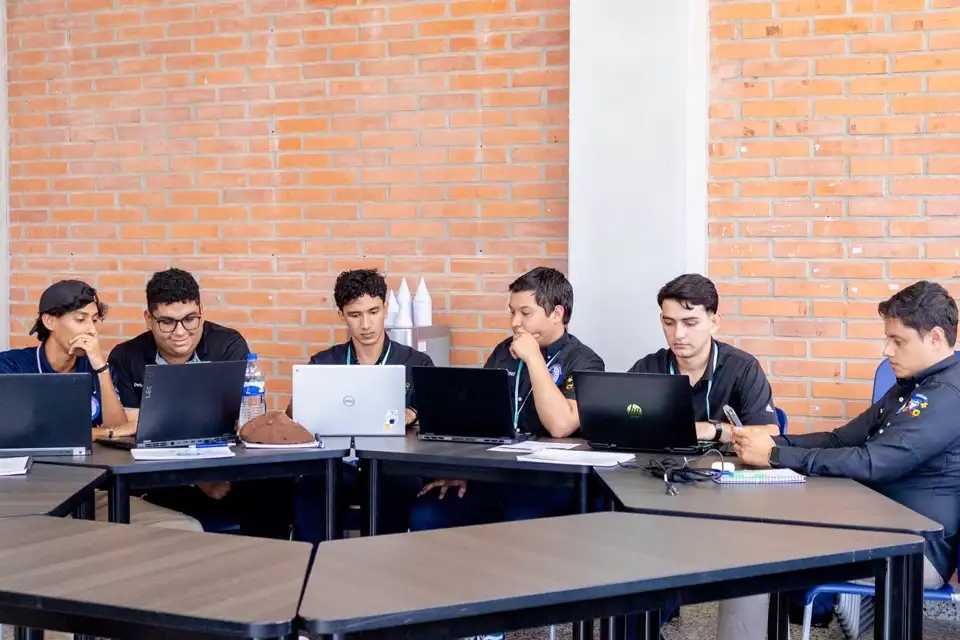 Estudiantes trabajando con sus laptops durante una sesión del bootcamp en UNICAH